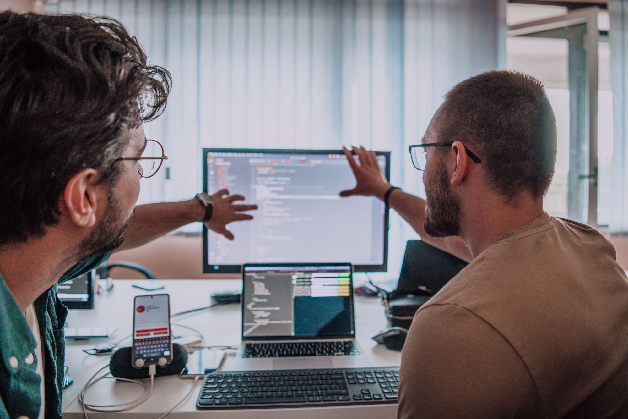 Two young men work on research together on a computer screen