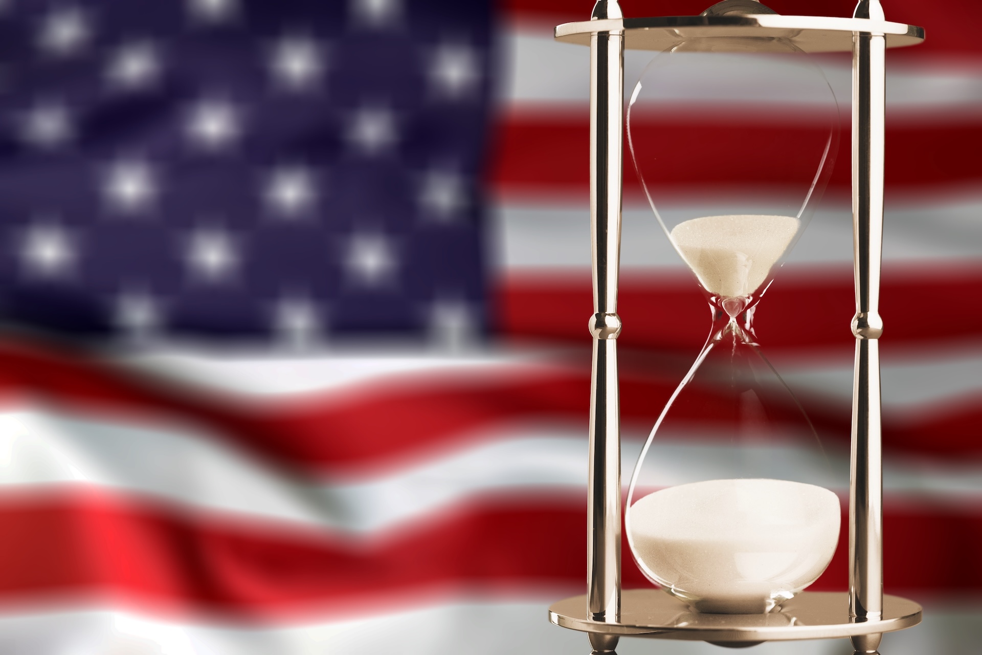 American flag with hourglass running down in front.