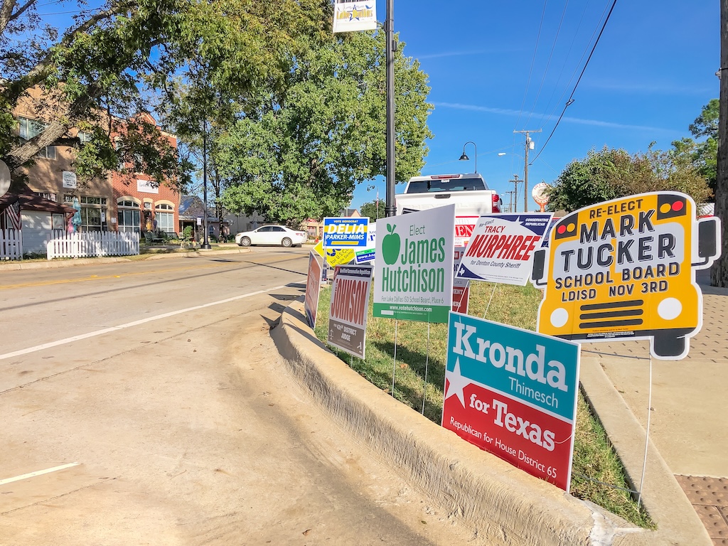 ROANOKE, TX, US-OCT 30, 2020: Row of presidential election poster yard sign near early voting location in main street Roanoke, Texas. Signs greeting early voters, political party posters for the election